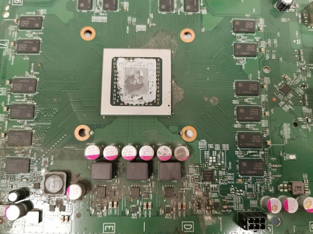 Procesor Xbox One przed naprawą – ślady zalania i stara pasta termoprzewodząca